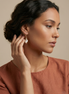 Caracola Gold Hook Earrings with clear cubic zircons and cat eye glass stone in lustrous gold finish