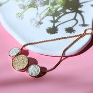 White Sandy Adjustable Bracelet with rose gold finish and dual circle accents on white sand background