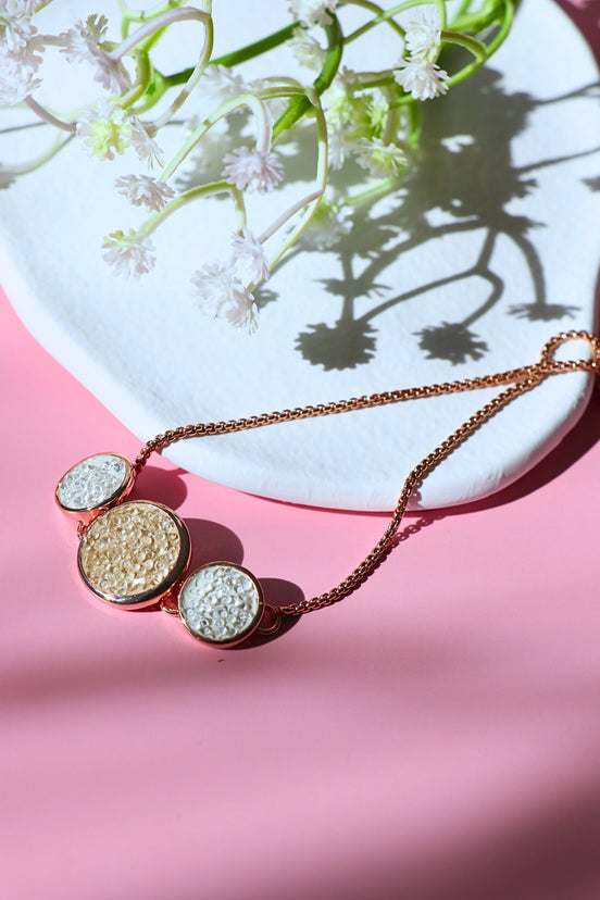 White Sandy Adjustable Bracelet with rose gold finish and dual circle accents on white sand background