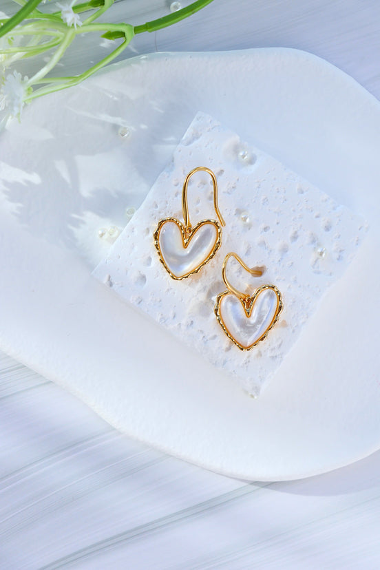 Gold hook earrings featuring white mother of pearl centerpiece with iridescent shimmer