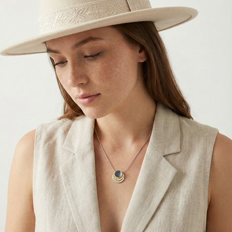 Woman wearing Kirana Tri Tone Necklace with dark grey, white, and gold pendant and adjustable chain
