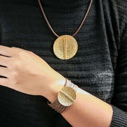 Golden Coin Cord Bracelet Australia & NZ - Woman wearing matching gold hammered disc pendant necklace and bracelet on brown cords