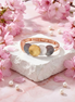 Verona Bracelet with four-tone gold, white, rose gold, and dark grey discs on elastic band surrounded by pink cherry blossoms and pearls
