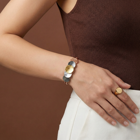 Verona Bracelet with four-tone gold, white, rose gold, and dark grey discs on elastic band worn on wrist