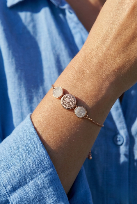 White Sandy Adjustable Bracelet with rose gold finish and dual circle accents on white sand background